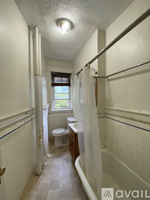 A bathroom with a toilet, sink and bathtub.