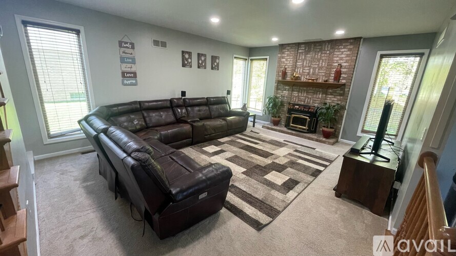 A living room with a large couch and a fireplace.