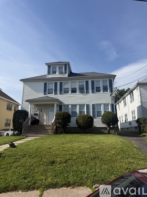 A two-story house with a white front door and a small porch.