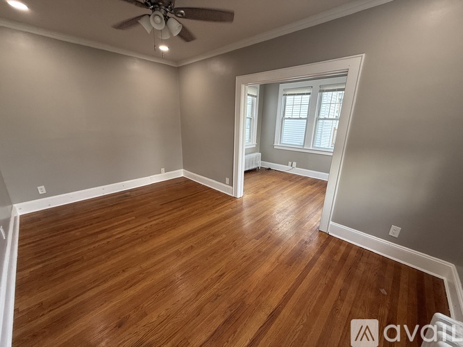 A room with wooden flooring and a ceiling fan.