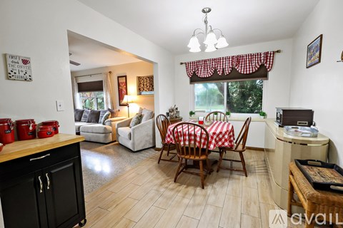 A kitchen with a dining table and chairs in the middle of the room.