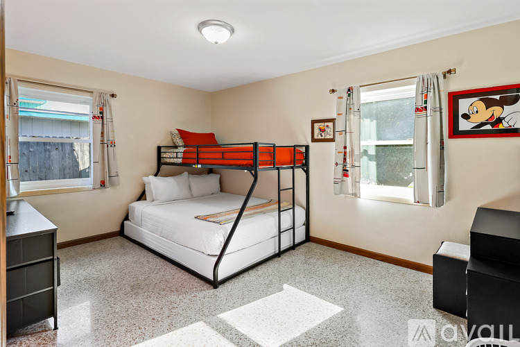 A bedroom with a bunk bed and a chair.