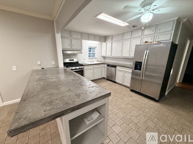 A kitchen with a marble countertop and stainless steel appliances.