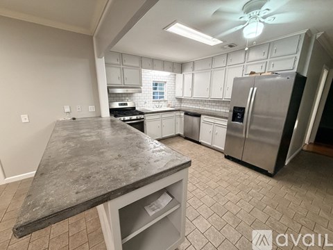 A kitchen with a marble countertop and stainless steel appliances.