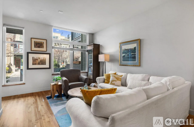 A living room with a white couch and a brown chair.