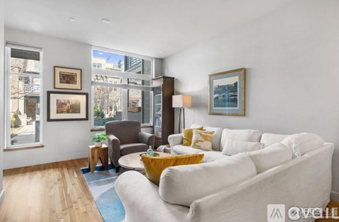 A living room with a white couch and a brown chair.