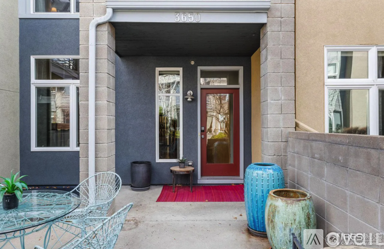 A modern house entrance with a red door and a glass window.