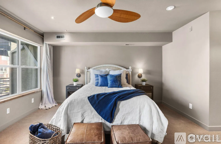 A bedroom with a large bed and a ceiling fan.