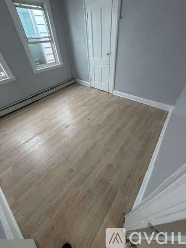 A room with wooden flooring and a white door.