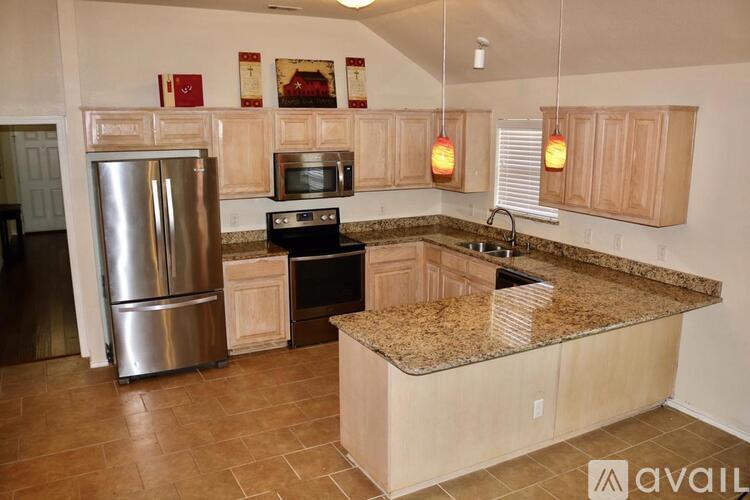 A kitchen with granite countertops and stainless steel appliances.