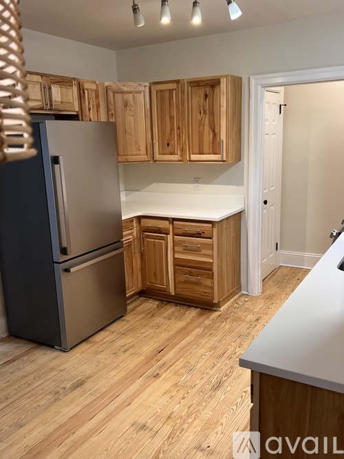 A kitchen with wooden cabinets and a white counter.