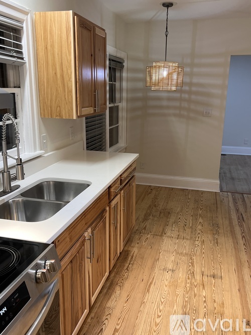 A kitchen with wooden cabinets and a stainless steel sink.