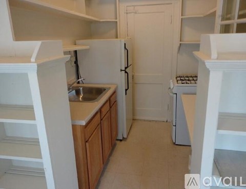 A small kitchen with a sink, refrigerator, and a dishwasher.