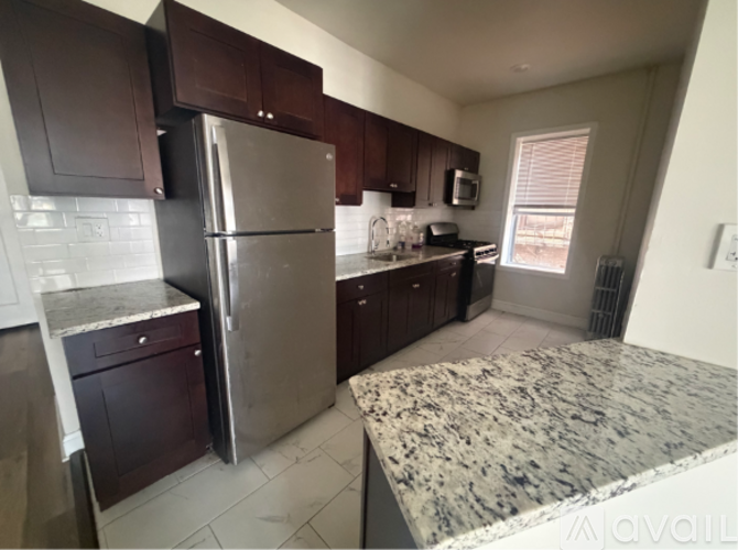 A kitchen with a granite countertop and stainless steel appliances.