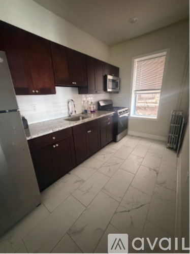 A kitchen with dark wood cabinets and a white refrigerator.