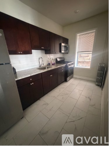 A kitchen with dark wood cabinets and a white refrigerator.