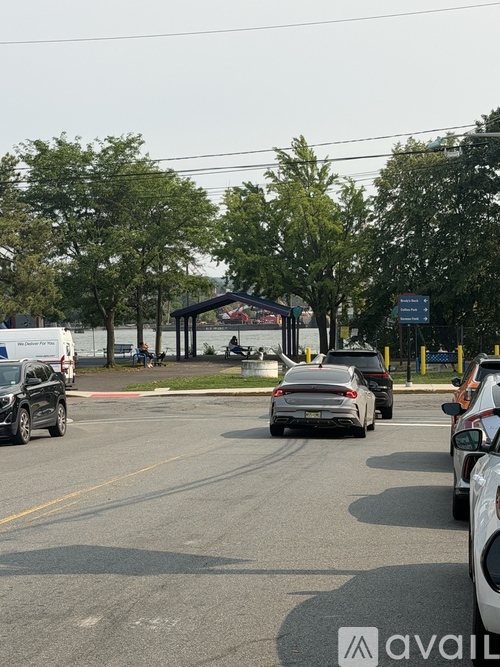 A parking lot with cars and a gazebo in the background.