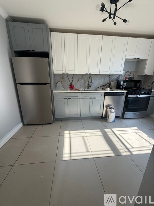 A kitchen with a refrigerator, stove, and cabinets.