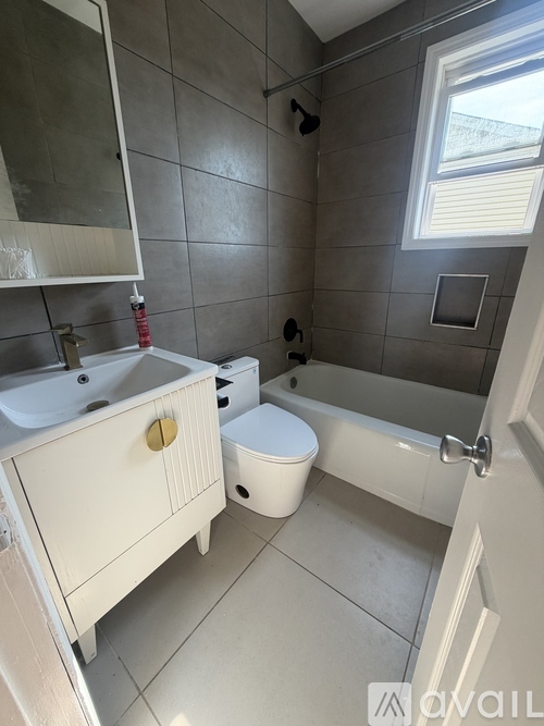 A white bathroom with a toilet, sink, and bathtub.