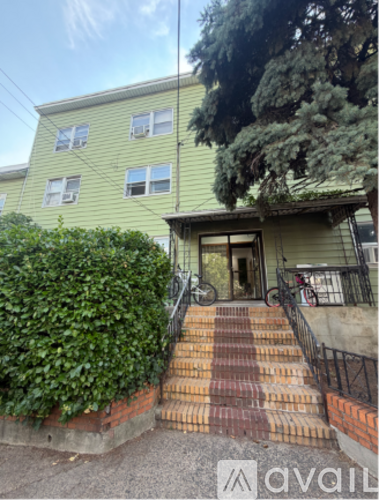 A house with a green exterior and a red brick staircase leading to the front door.