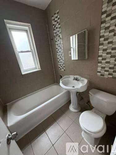 A bathroom with a white toilet, sink, and bathtub.