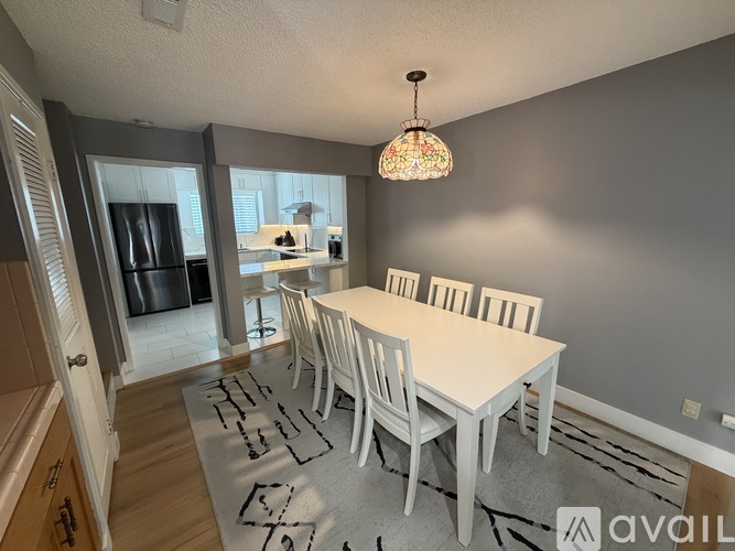 A dining room with a white table and chairs.