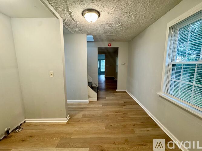 A long hallway with wood floors and white walls.
