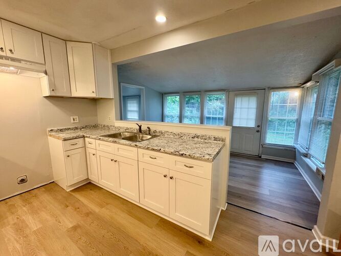 A kitchen with white cabinets and a granite countertop.