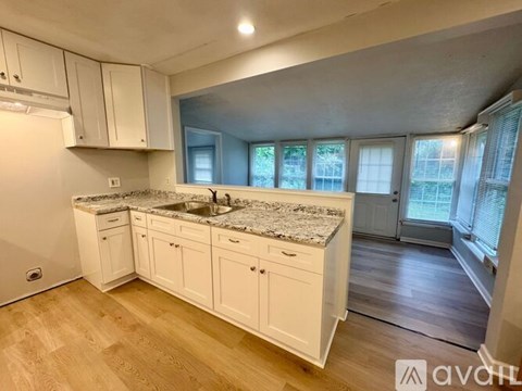 A kitchen with white cabinets and a granite countertop.