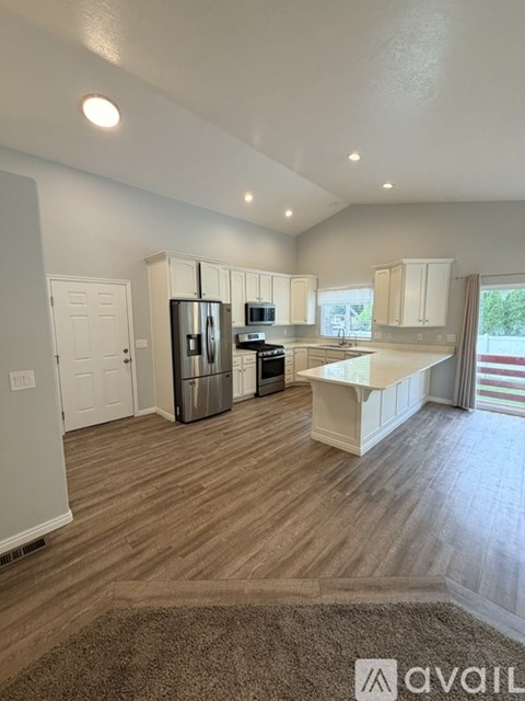 A kitchen with white cabinets and a refrigerator.