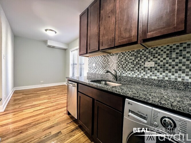 A kitchen with wooden floors and a checkered backsplash.