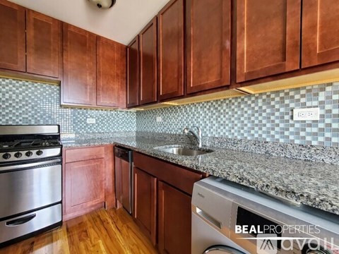 A kitchen with wooden cabinets and a checkered backsplash.