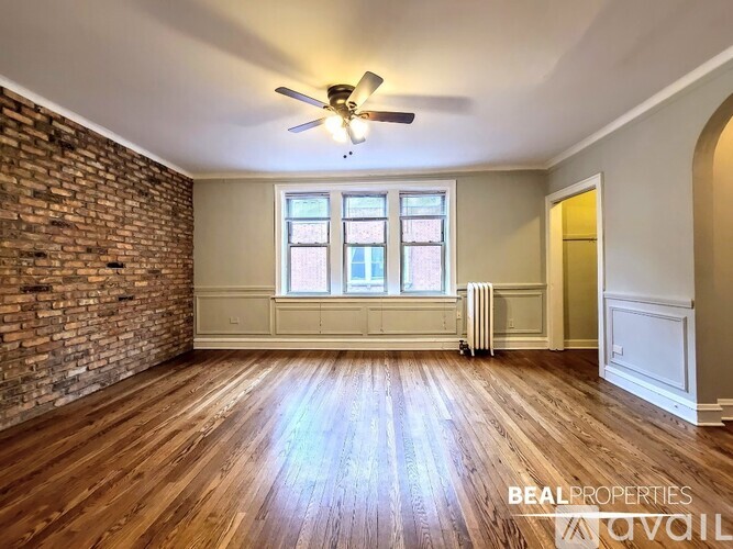 A room with wooden floors and a brick wall.