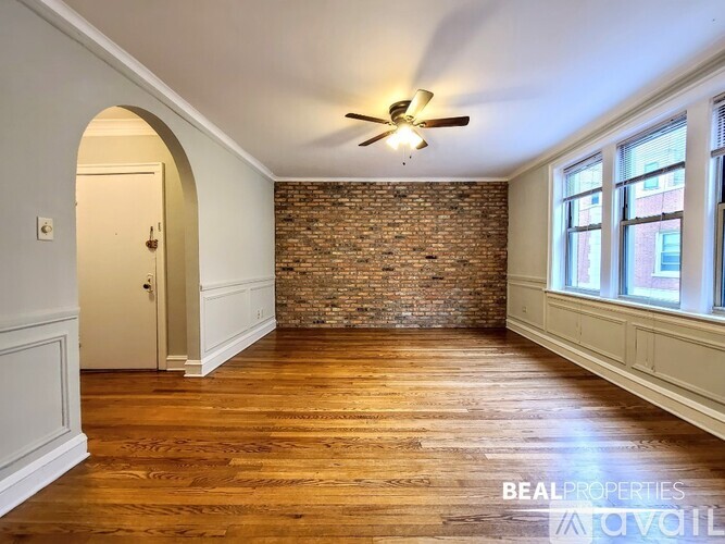 A room with wooden floors and a brick wall.