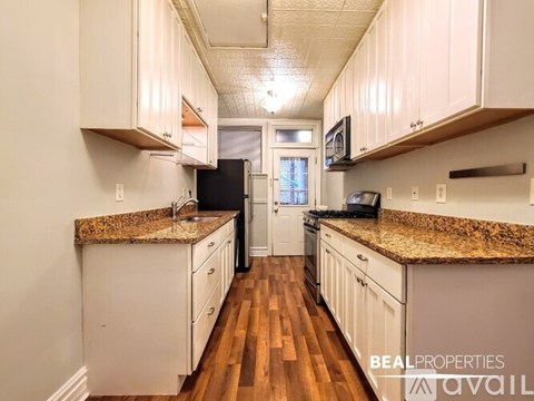 A kitchen with white cabinets and granite countertops.