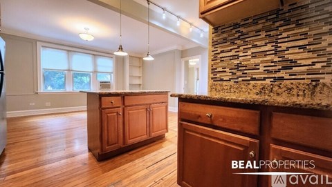 A kitchen with wooden cabinets and a stone wall.