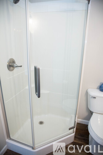 A glass shower stall with a door and a handle.