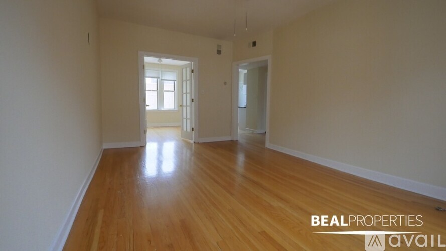 A room with wooden floors and two doors.