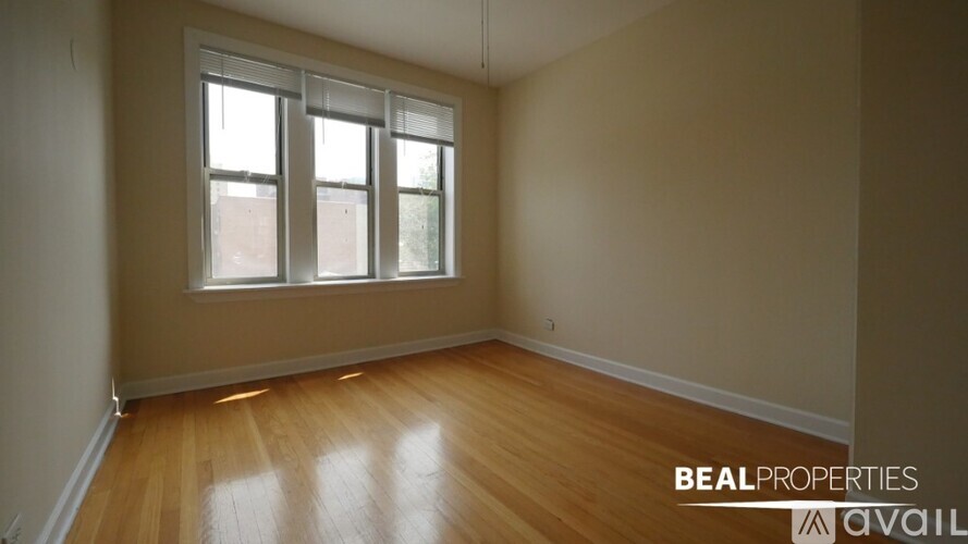 A room with wooden floors and a window is available for rent.