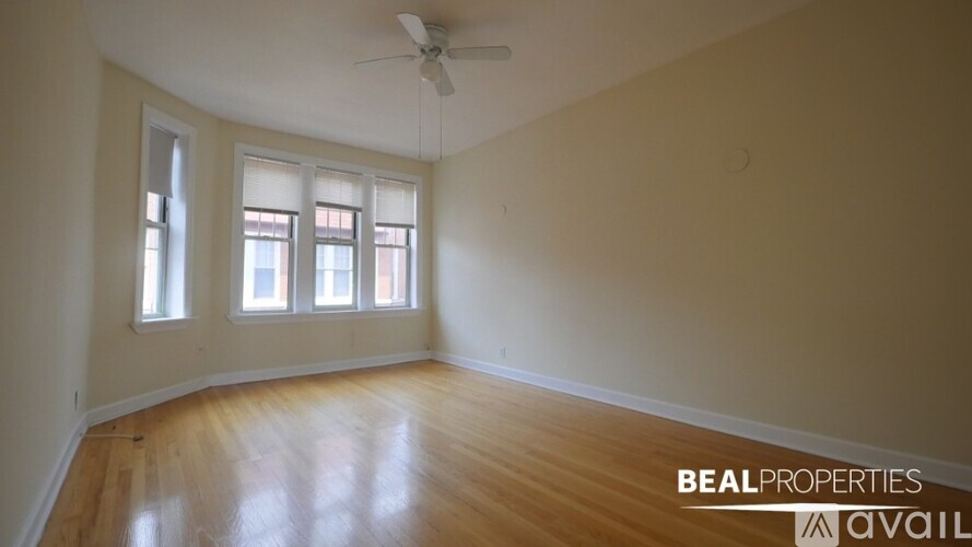 A room with wooden floors and a window with blinds.