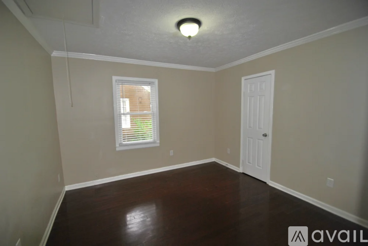 A room with a window and a door is available for rent.