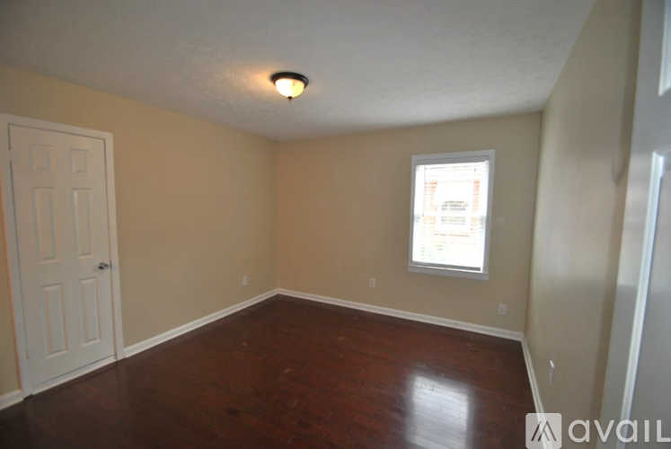 A room with a white door and a window with a sign on it.
