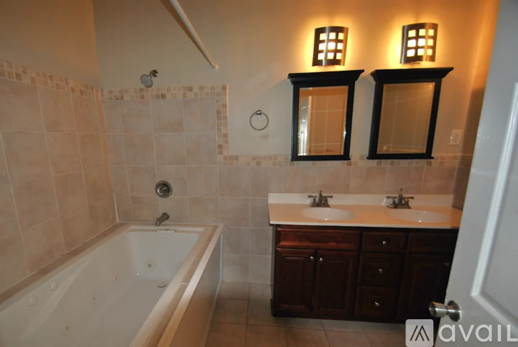 A bathroom with a tub, sink, and mirror.