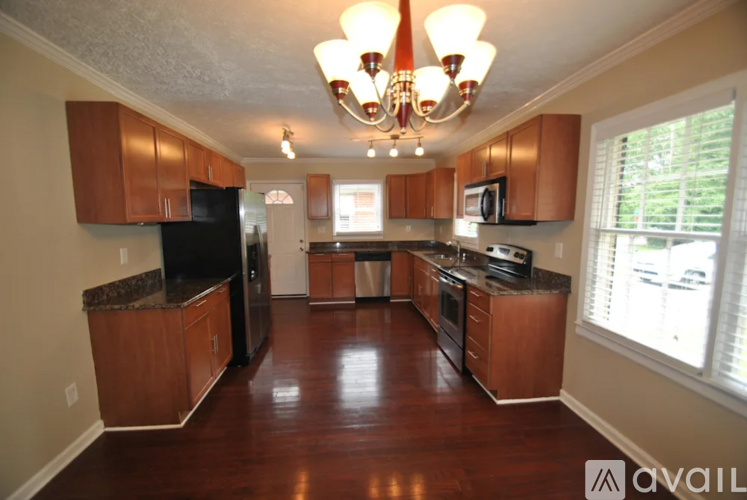 A kitchen with wooden cabinets and a black refrigerator.