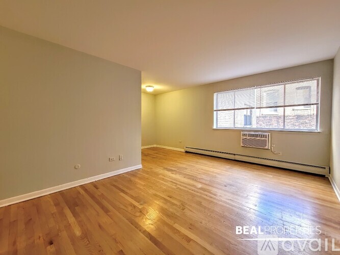 A room with wooden flooring and a window.
