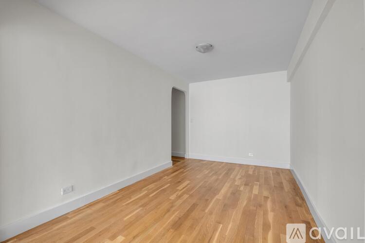 A room with wooden flooring and white walls.