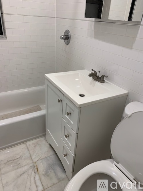 A white bathroom with a toilet, sink, and bathtub.