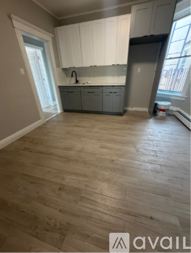 A kitchen with wooden floors and white cabinets.