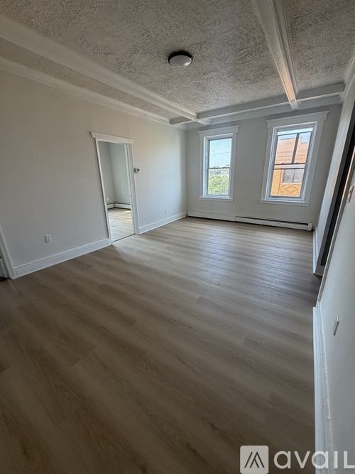 A room with wooden flooring and a window.