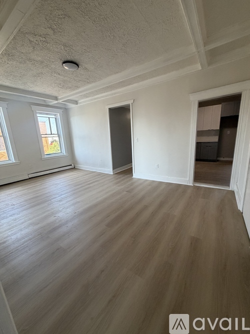 A room with wooden flooring and white walls.